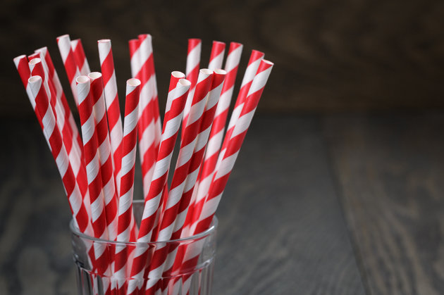 vintage paper straws in glass on wood table, rustic style